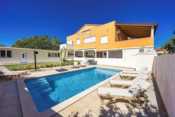 A modern two-story house with a swimming pool, outdoor seating, and a covered patio. - Apartment with pool in Medulin A1 (Medulin)
