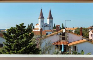 A view of a church with two towers, surrounded by residential buildings with red-tiled roofs. - Apartment with pool in Medulin A1 (Medulin)