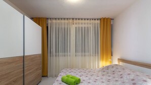 A bedroom with a bed, a wardrobe, and a window with curtains. - Apartment with pool in Medulin A3 (Medulin)