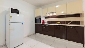 A modern kitchen with a refrigerator, microwave, and stove. - Apartment with pool in Medulin A3 (Medulin)