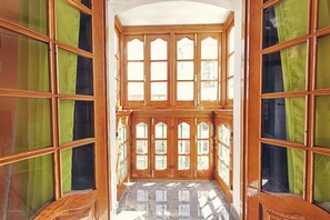 A room with large wooden-framed windows and green curtains. - Charming Nerja Hostel (Nerja)