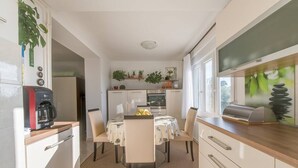 Une cuisine compacte comprenant une table à manger, des chaises, une machine à café et un grille-pain.
