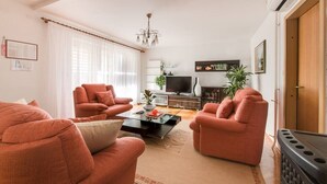 Un salon avec deux canapés, une table basse, un téléviseur et une cheminée.