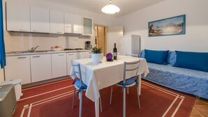 A compact living space with a kitchenette, dining area, and a sofa.