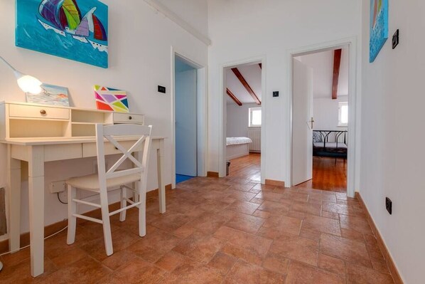 A room with a desk, chair, and a bed in the background. - Villa Tanga near Rovinj for 8 persons with pool (Rovinj)