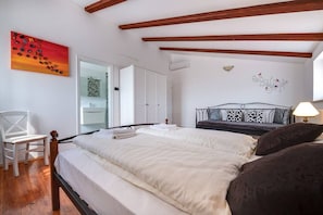 A bedroom with a large bed, a chair, a wardrobe, and a painting on the wall. - Villa Tanga near Rovinj for 8 persons with pool (Rovinj)