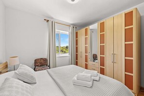 A bedroom with a bed, a chair, a wardrobe, and a window. - Holiday Home with pool and garden - Tervis (Trviž)