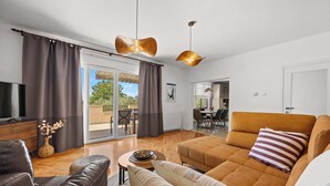 A modern living room with a sofa, a coffee table, and a television.