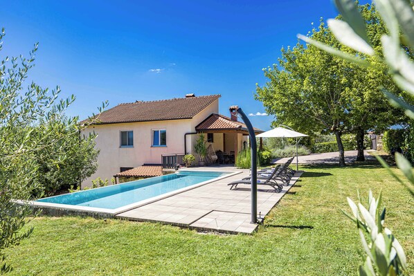 A house with a swimming pool, a patio with lounge chairs, and a garden. - Holiday Home with pool and garden - Tervis (Trviž)