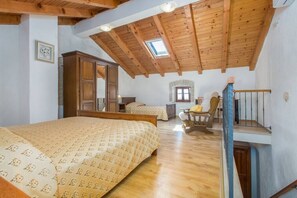 A bedroom with a wooden ceiling, a bed, a chair, and a staircase. - Holiday Homes Ana & Maria - Family Home Maria (Kanfanar)