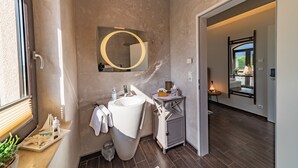 A modern bathroom with a large sink, mirror, and a small vanity.