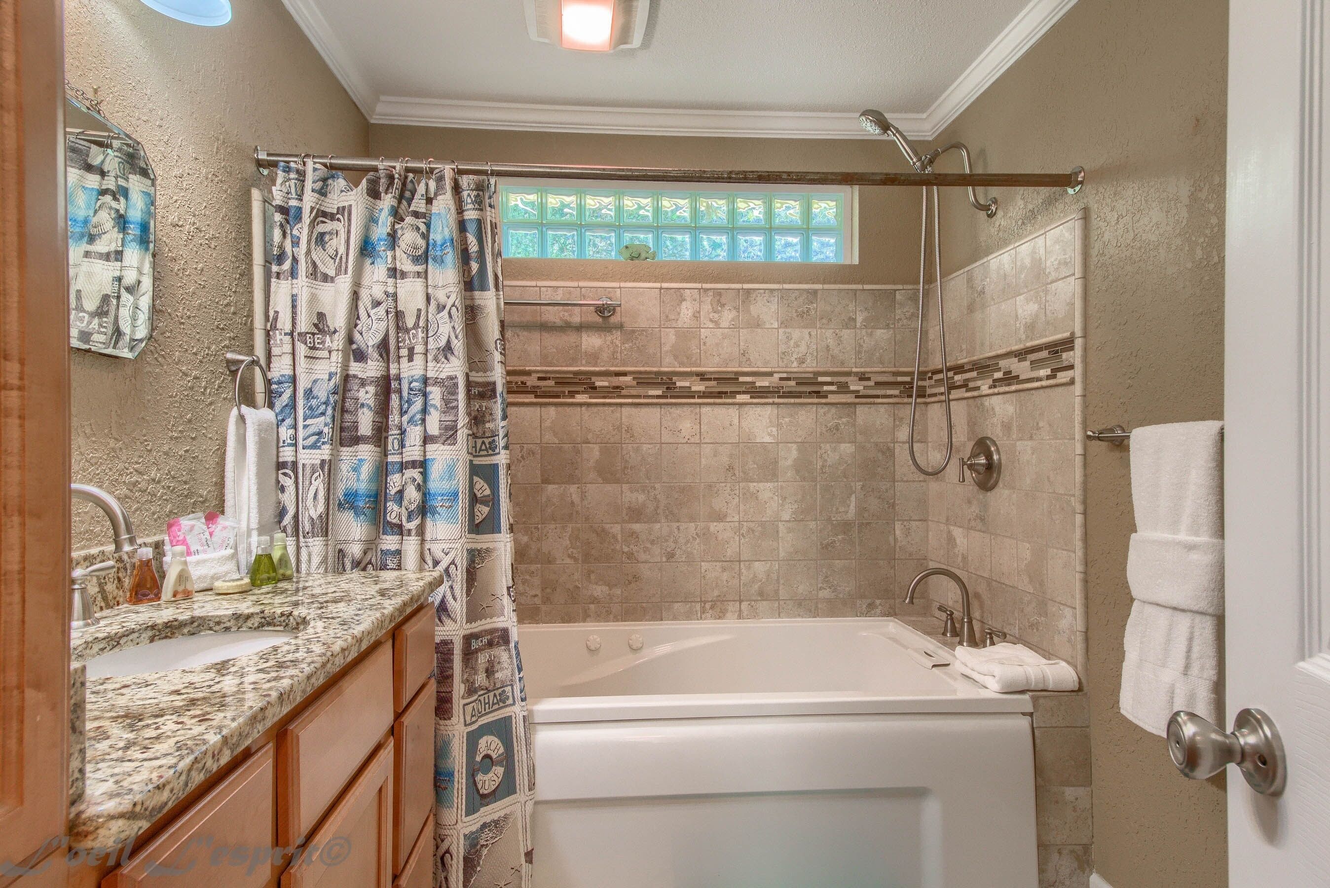 A bathroom with a bathtub, shower, and a window with a view.