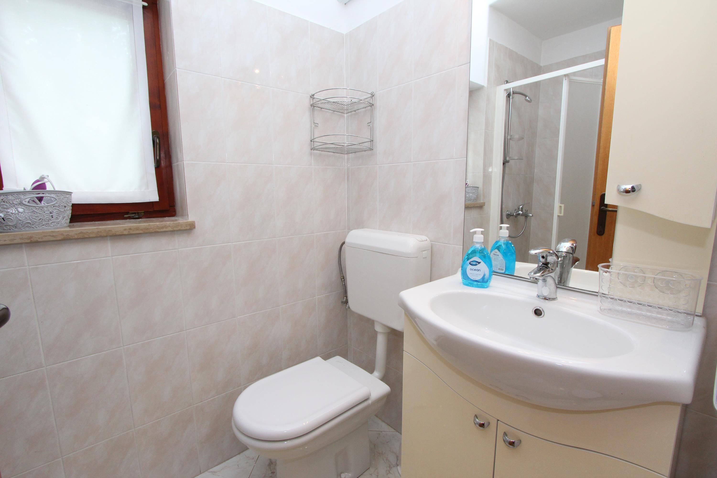 Un baño con inodoro, lavabo y ducha.