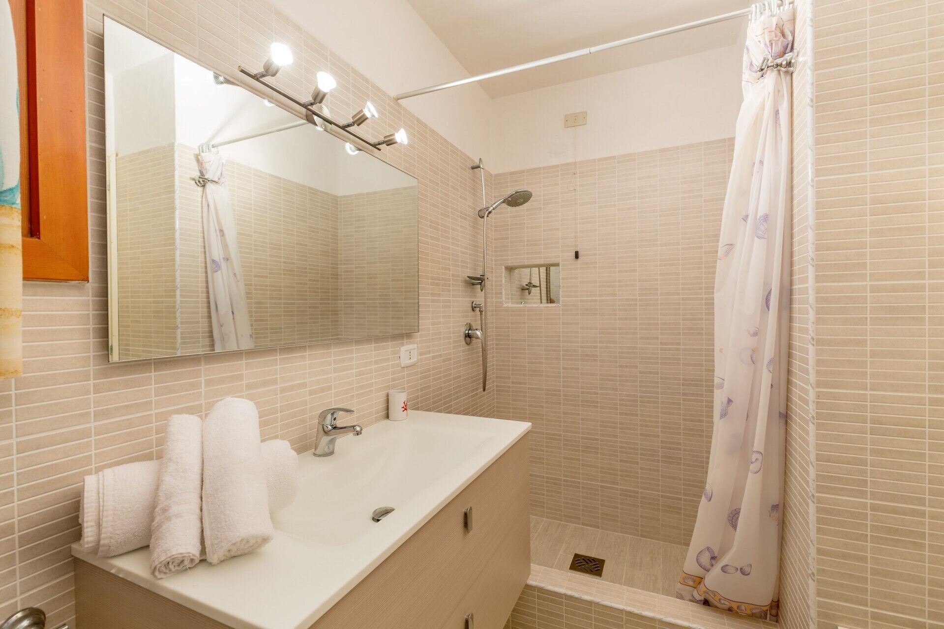 Ein Badezimmer mit Waschbecken, Spiegel und Dusche.