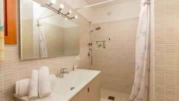 Ein Badezimmer mit Waschbecken, Spiegel und Dusche.