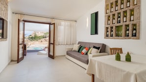Una habitación amplia con vista a una piscina, un armario para vinos empotrado y un comedor.