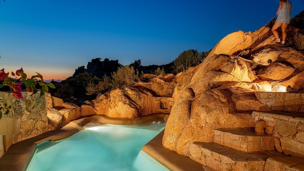 Una fuente termal natural rodeada de escalones de piedra y una poza cristalina.
