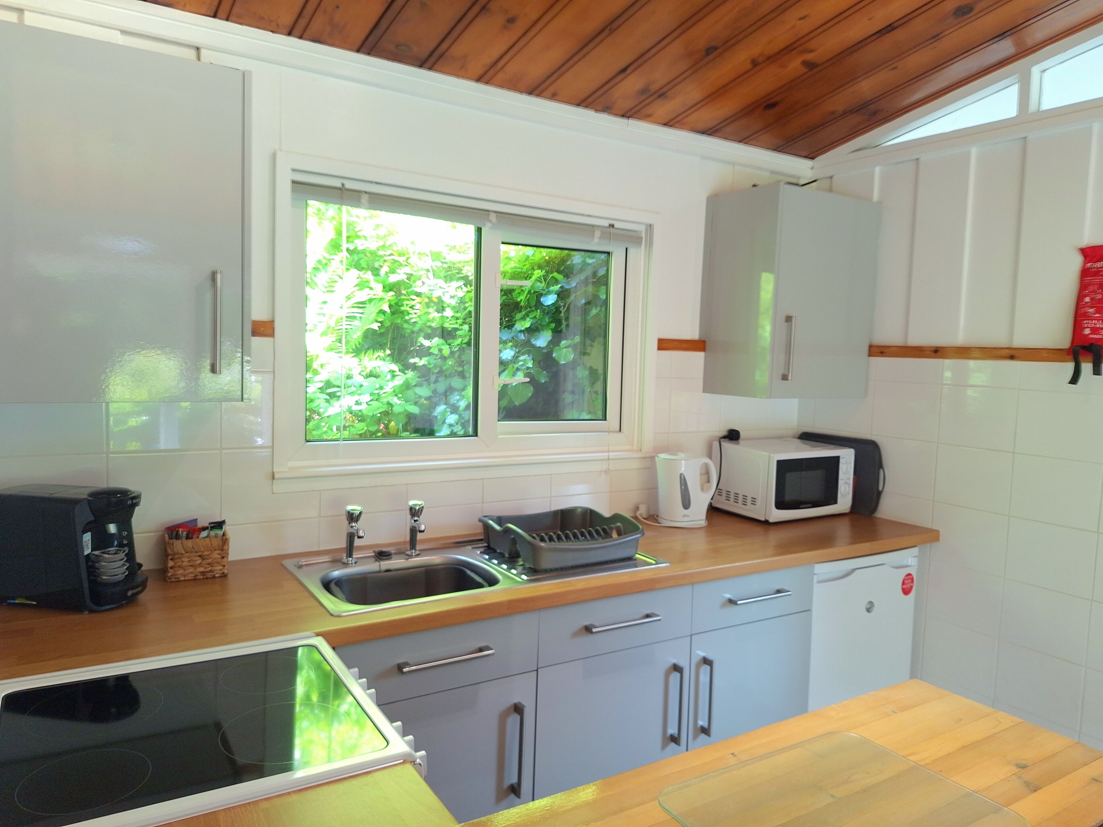 A modern kitchen with a built-in dishwasher, a microwave, and a coffee maker.