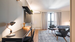 Quarto de hotel moderno com escrivaninha, cadeira e cama.