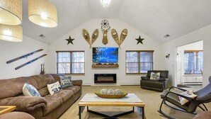 Een woonkamer met een open haard, een televisie en een groot raam.
