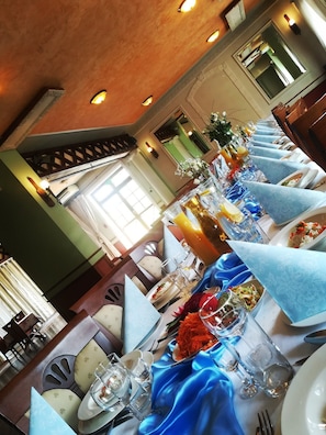 A long dining table with blue napkins, clear glassware, and various dishes.