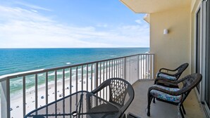 A balcony with wicker chairs overlooking a beach and ocean. - 16th-Floor Gulf-Front Condo at Boardwalk – Balcony Views, Resort Pool & Hot Tubs (Panama City Beach)