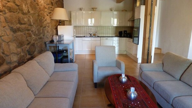 A cozy living room with two sofas, a coffee table, and a stone wall. - Family-friendly holiday home with a large playroom and garden. Pet-friendly! (Janowice Wielkie)