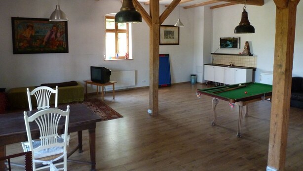 A spacious room with a pool table, wooden beams, a television, and a dining area with chairs. - Family-friendly holiday home with a large playroom and garden. Pet-friendly! (Janowice Wielkie)