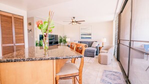 Una cocina moderna con encimera de granito, taburetes de madera y una isla central.