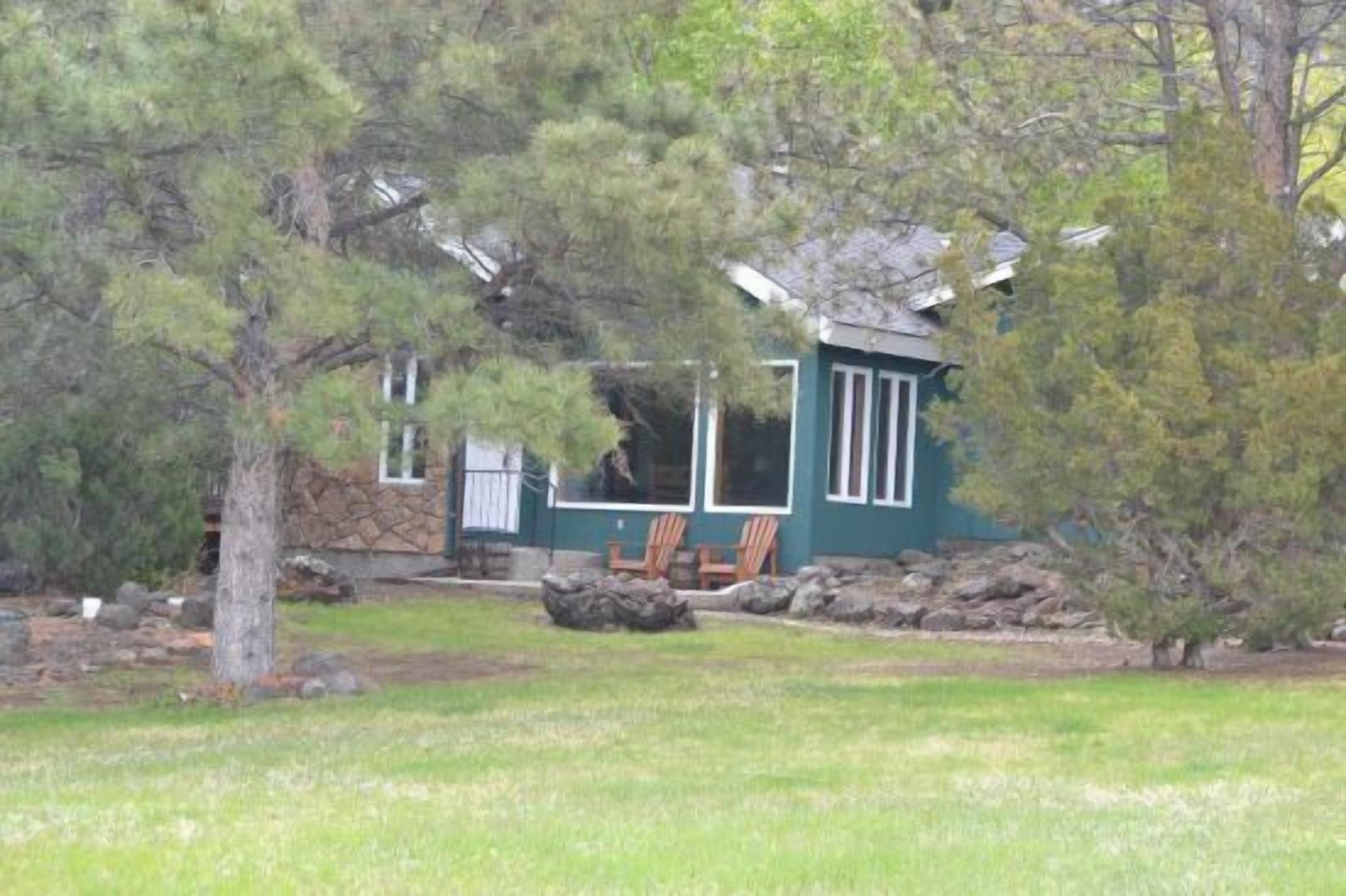 Creekworks Cabin, located in Wapiti Valley, surrounded by trees with creek access