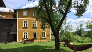Ein zweistöckiges Gebäude mit einer gelben Fassade und zahlreichen Fenstern.