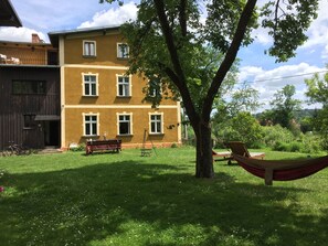 Un immeuble de deux étages avec une façade jaune et de nombreuses fenêtres.