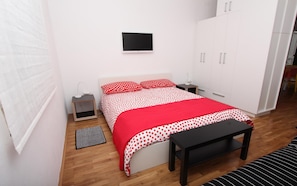 Cozy retreat with a single bed, bedside table, and flat-screen TV.