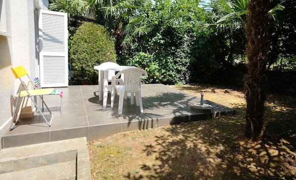 Enjoy dining or socializing in this serene outdoor space surrounded by lush greenery and a tranquil atmosphere.