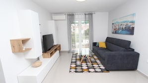 Ein modernes Wohnzimmer mit einem grauen Sofa, einem Glastisch und einem Bild an der Wand.