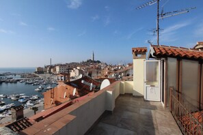 A coastal town with a marina, buildings with red-tiled roofs, and a prominent tower in the distance. - Apartment Zara (Rovinj)