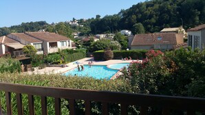 A residential area with a swimming pool surrounded by lush greenery and houses with tiled roofs. - Résidence Provençale 2 Rooms Swimming pool Parking WIFI 2 kms Sea Villeneuve Loubet  (Villeneuve-Loubet)