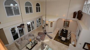 A spacious living area with a high ceiling, large windows, and a dining area. - Las Olas Waterfront Mansion (fort lauderdale)