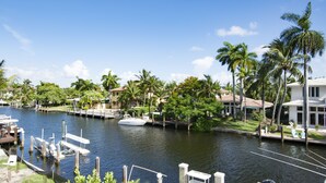 A marina with docked boats, a calm water body, and surrounding greenery including palm trees. - Las Olas Waterfront Mansion (fort lauderdale)
