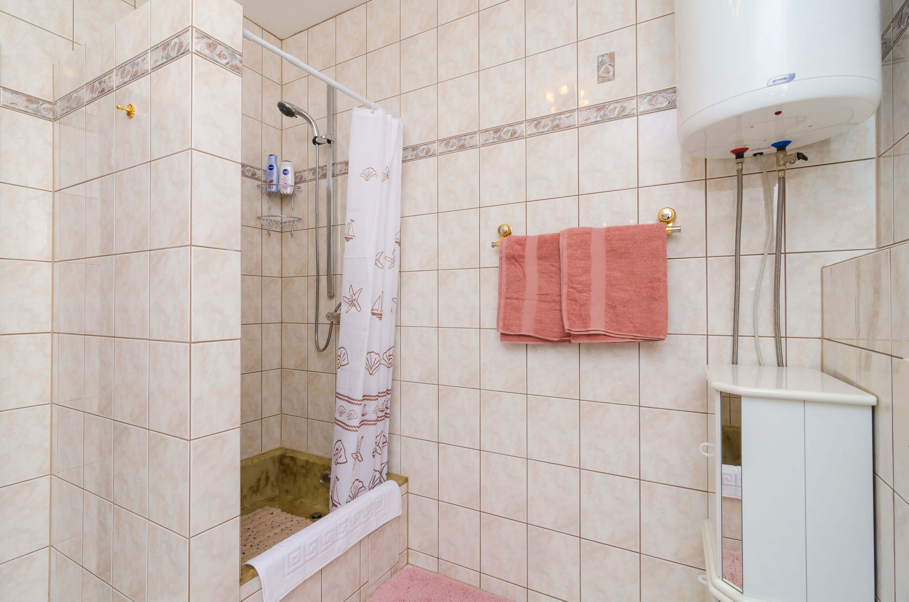 A bathroom with a shower, a bathtub, and a toilet.
