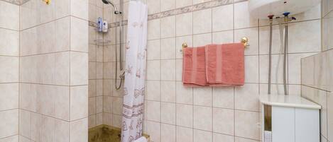 A bathroom with a shower, a bathtub, and a toilet.