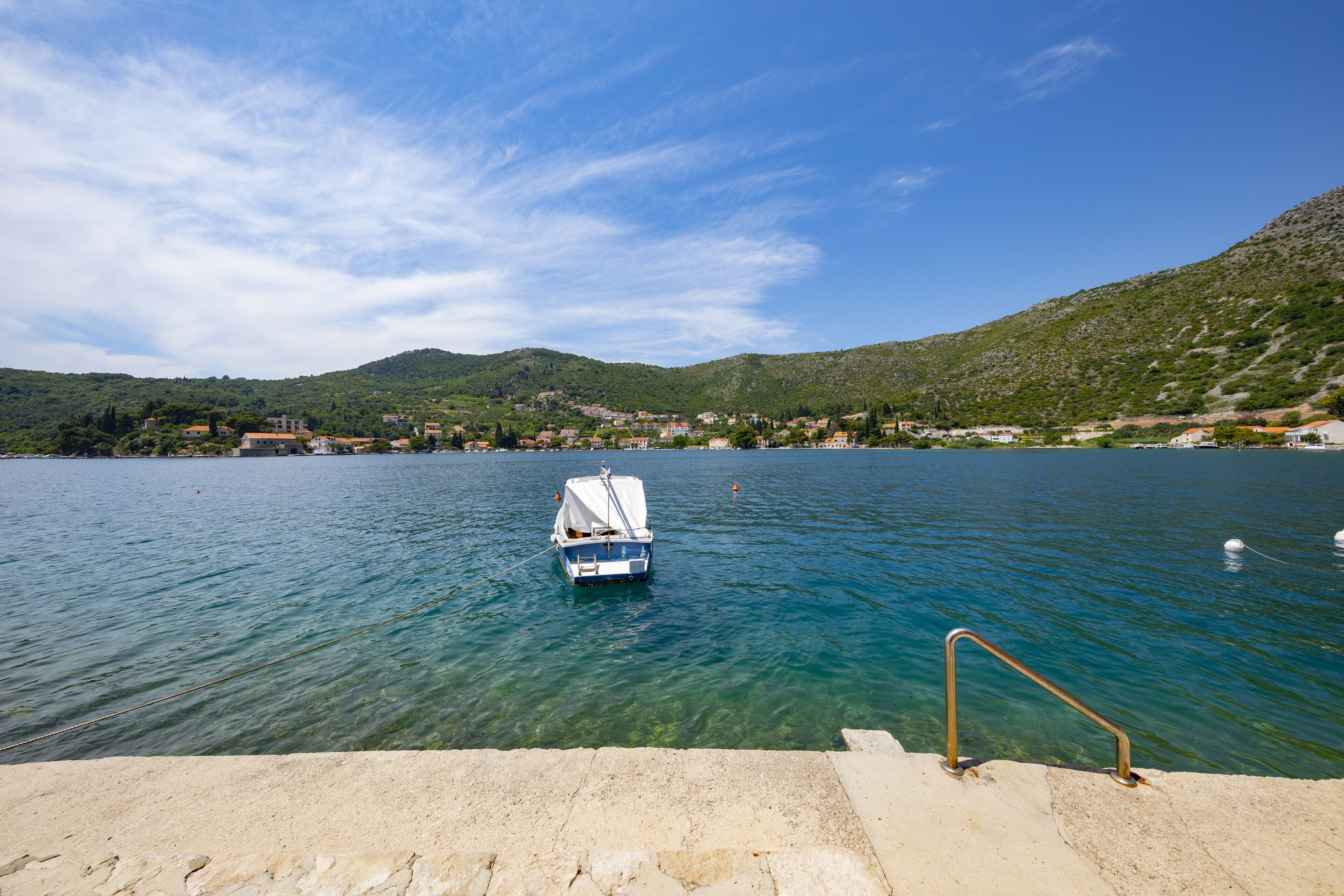 A boat docked at a pier with a clear view of a mountainous landscape in the background.