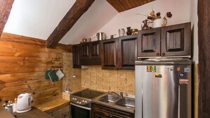 Eine Küche mit Holzschränken, einem Edelstahlkühlschrank, einem Herd und einer Spüle.