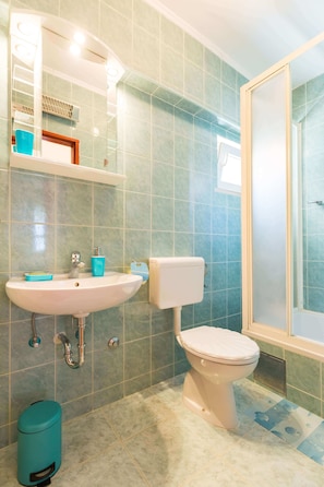 A bathroom with a sink, toilet, and shower. - Anika Apartment (Dubrovnik)
