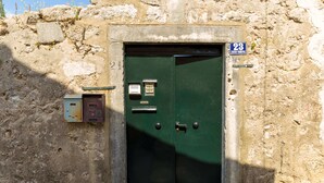 Une porte verte avec une plaque portant un numéro et un petit panneau au-dessus.