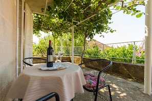A table set with a bottle of wine, two wine glasses, and a lace doily. - Anika Apartment (Dubrovnik)