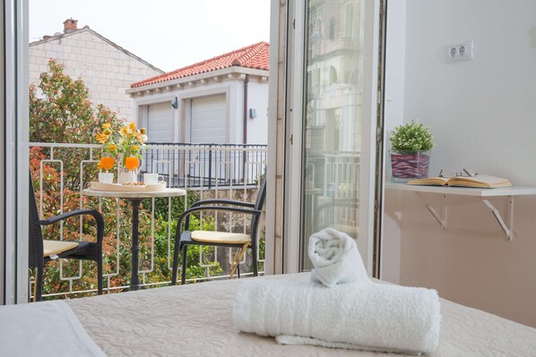 A balcony with a table, chairs, and a potted plant. - Apartments Koncul (Dubrovnik)