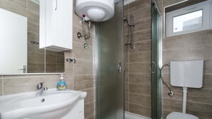 Ein Badezimmer mit Waschbecken, Toilette, Dusche und einem Fenster.