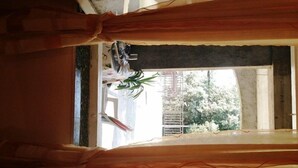 Una habitación con ventana, cortinas y una planta.