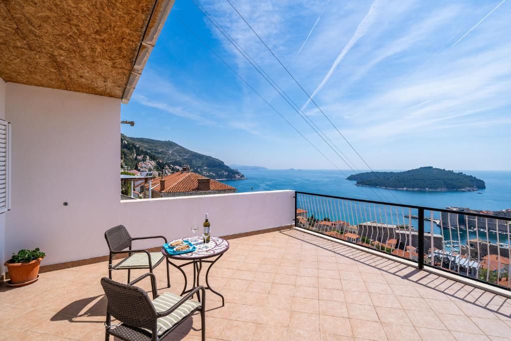 A balcony with a view of the sea and a distant island.